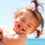 Menina ao sol com mar e céu de fundo