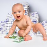 Bebé com dinheiro e fraldas descartáveis