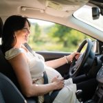 Mulher grávida a conduzir automovel com cinto de segurança