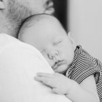 pai a adormecer o bebé ao colo